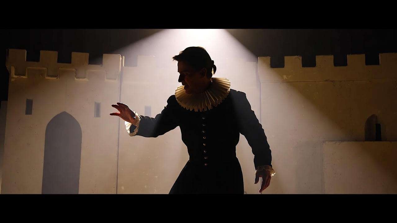 Silhouette of an actor in Hamlet costume on stage with castle walls, highlighting theatrical impact of his age