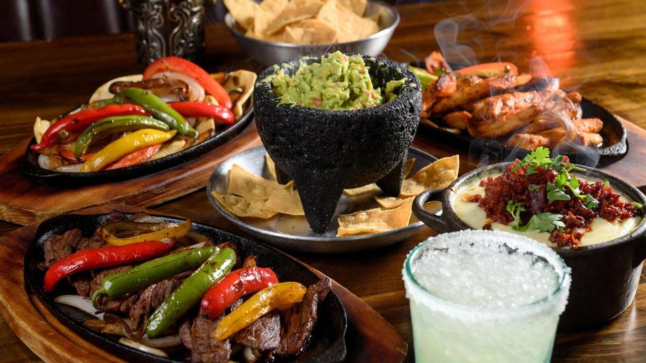 Uncle Julio’s fajitas, guacamole, and margarita showcasing 2025 menu pricing categories