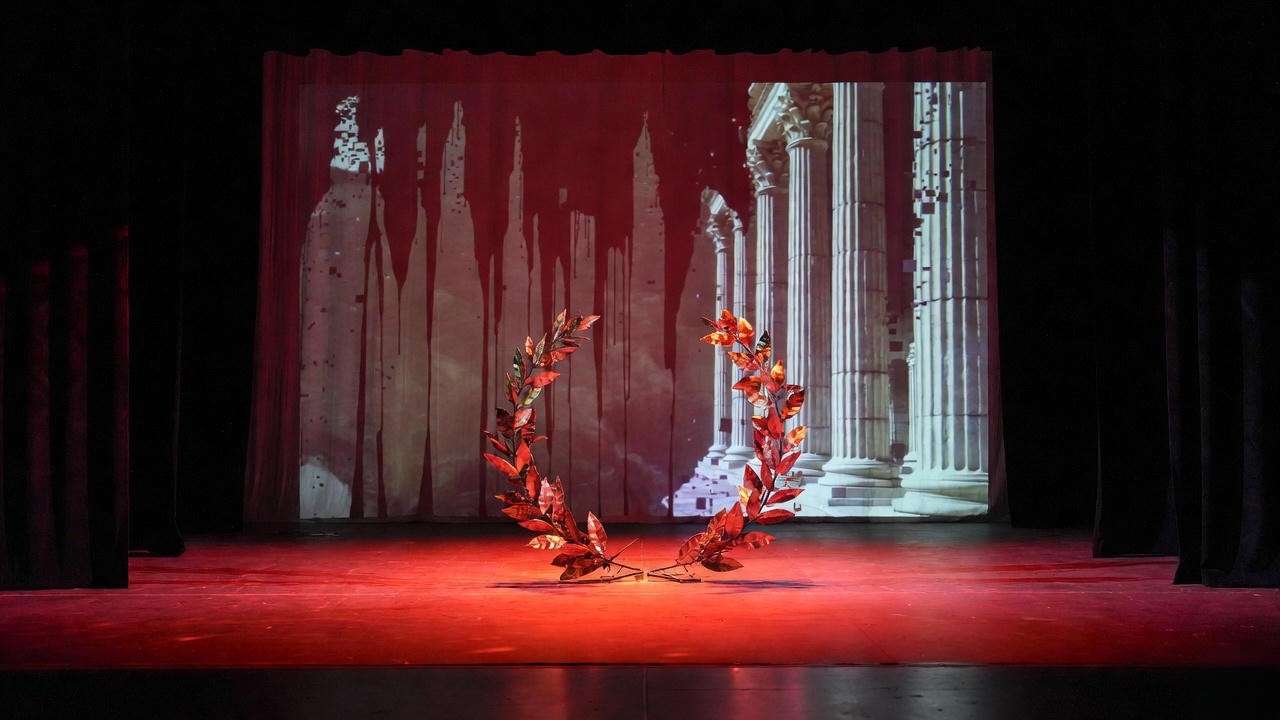 Modern minimalist staging of Julius Caesar play with broken laurel wreath and digital Rome