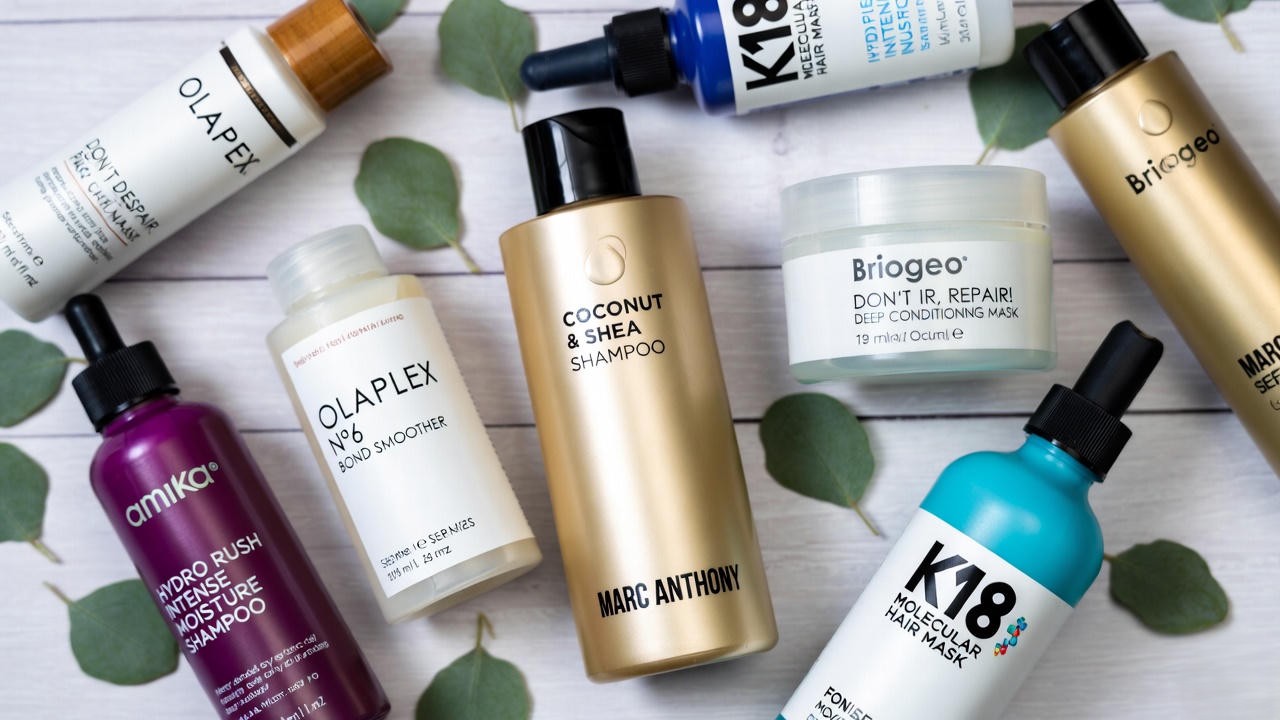 Marc Anthony leave-in conditioner compared with Olaplex, Briogeo, Amika and K18 in flat lay
