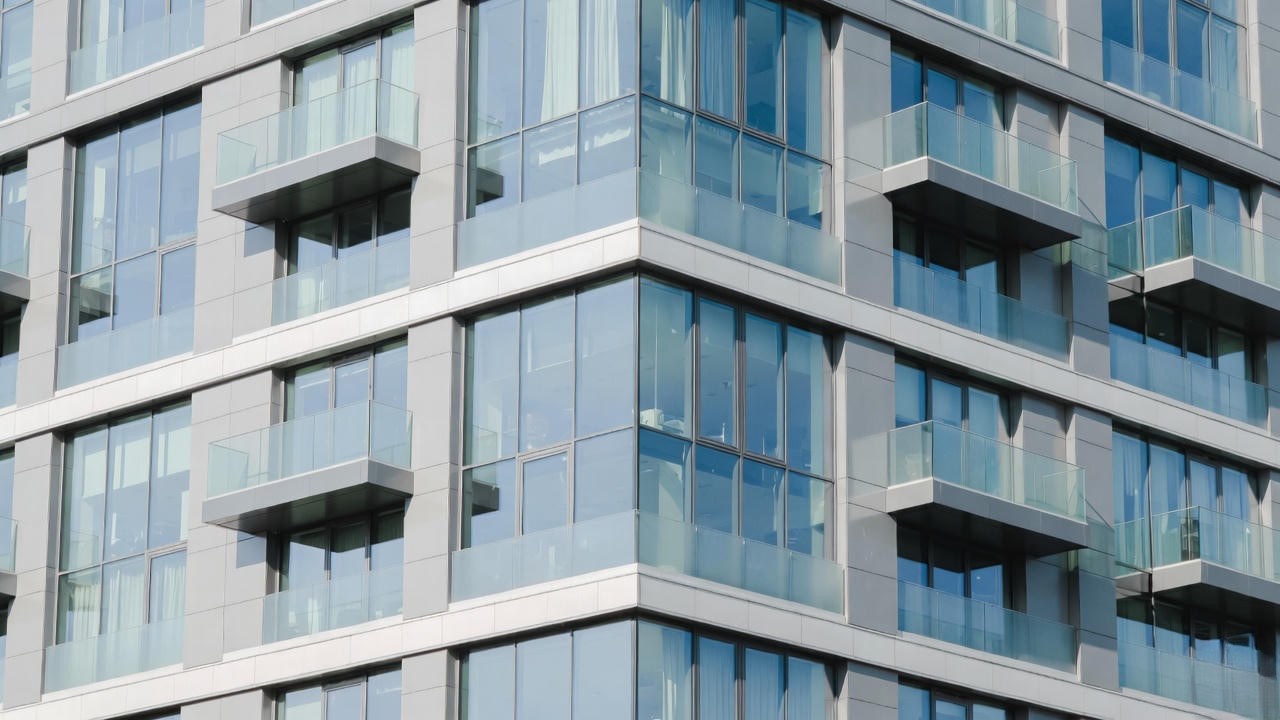 Modern glass Juliette balcony on contemporary apartment building, inspired by Romeo and Juliet romantic aesthetic.