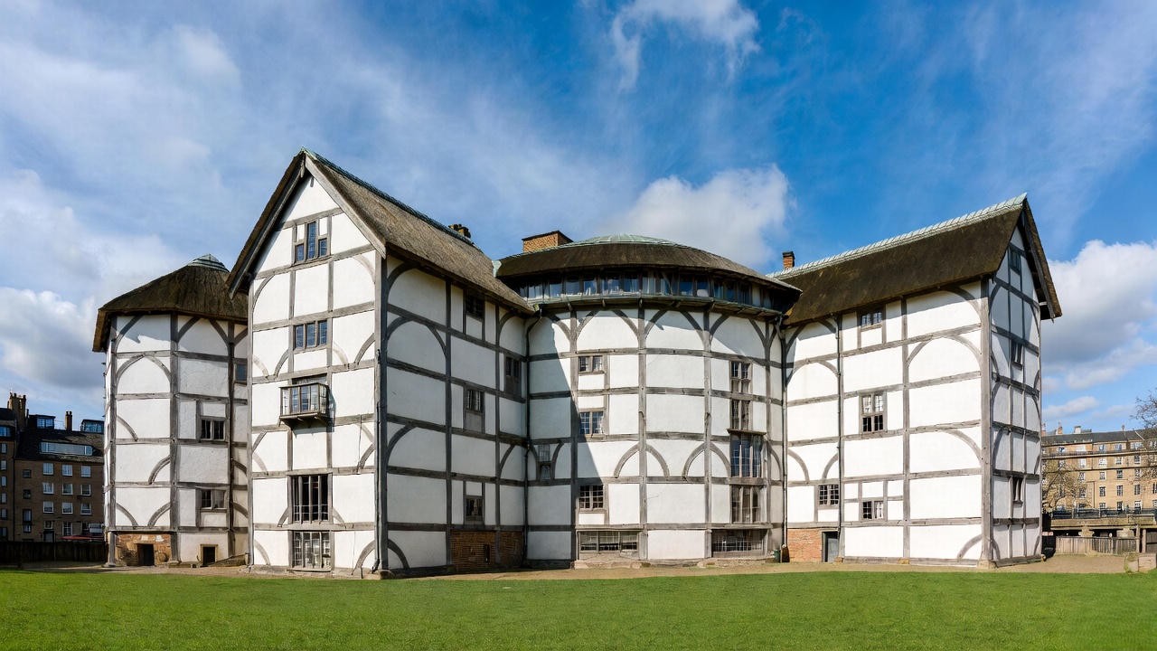 Modern reconstruction of Shakespeare's Globe Theatre in London, viewed to emphasize its iconic round design and Elizabethan features.