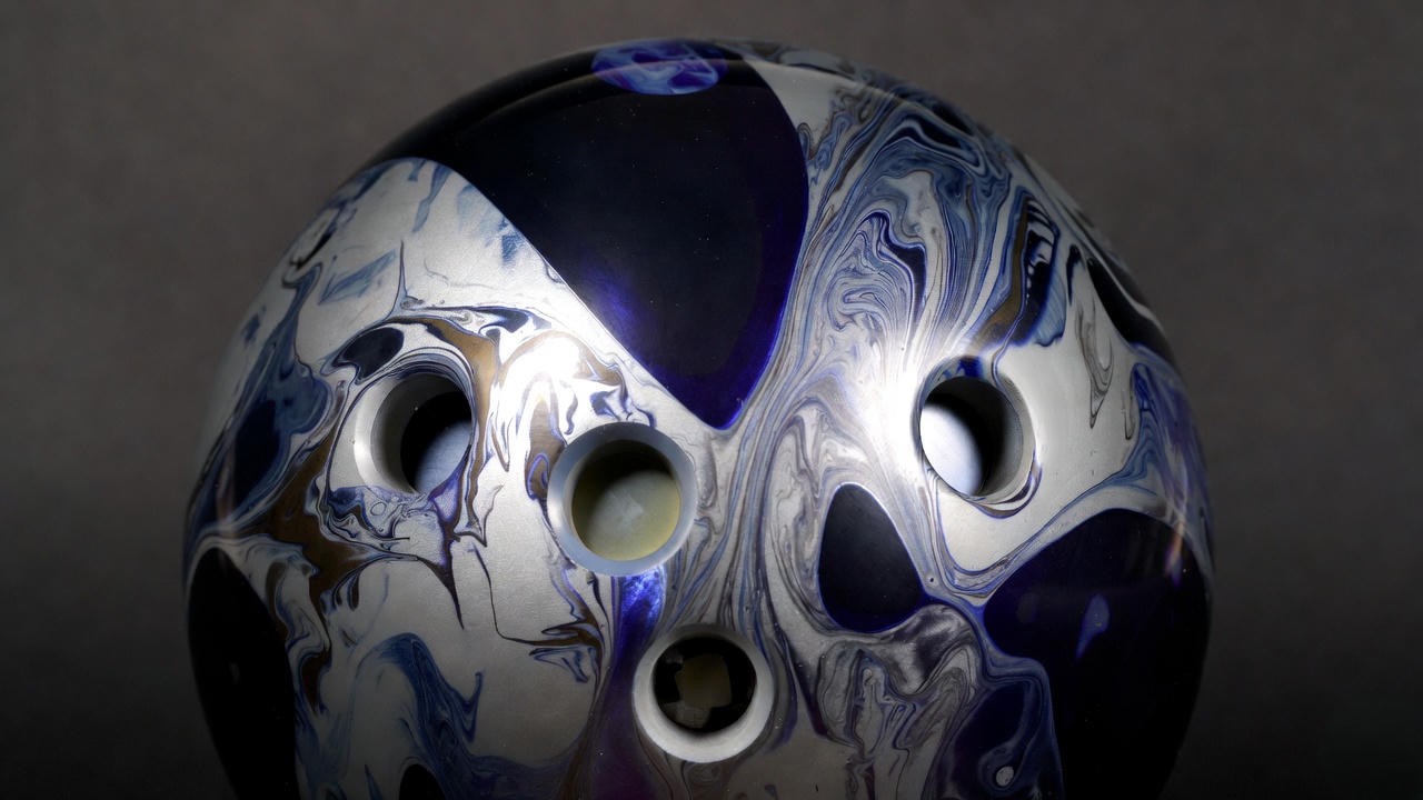 Close-up of the 900 Global Harsh Reality bowling ball with atomic graphite black swirl design and glossy finish.