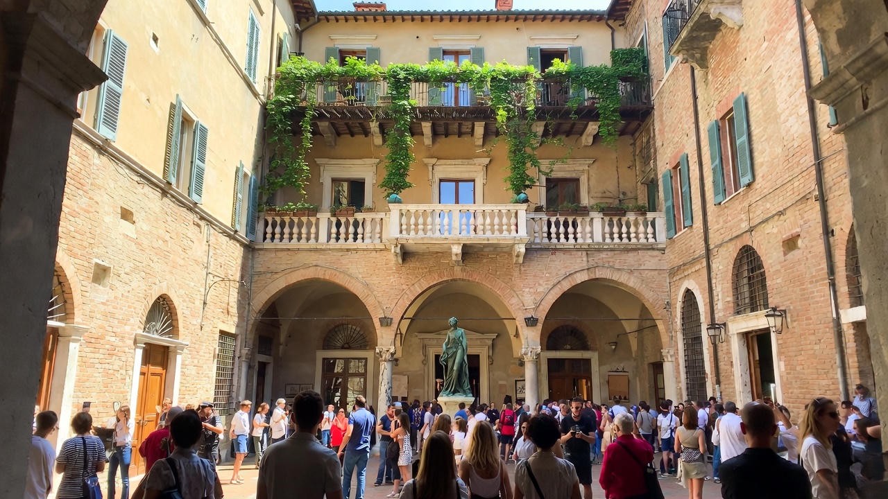 Juliet’s House courtyard with famous balcony and statue in modern Verona
