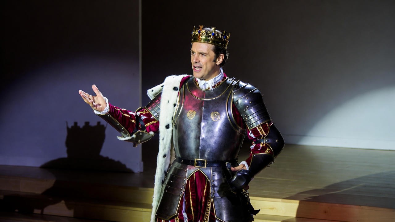 Actor portraying Shakespeare's legendary Henry V on stage, contrasting the mythic Prince Hal.