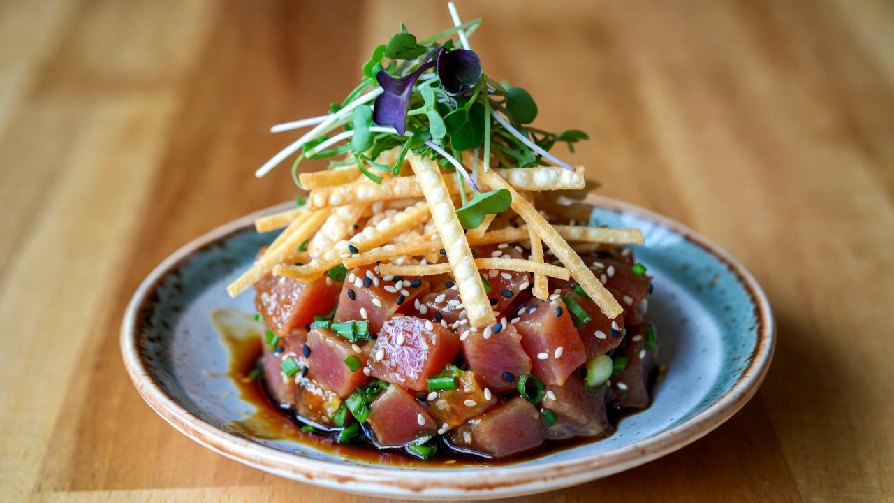 Fresh Maui-style ahi poke starter from Hamlet & Ghost menu, vibrant tuna with sesame and green onion garnishes.