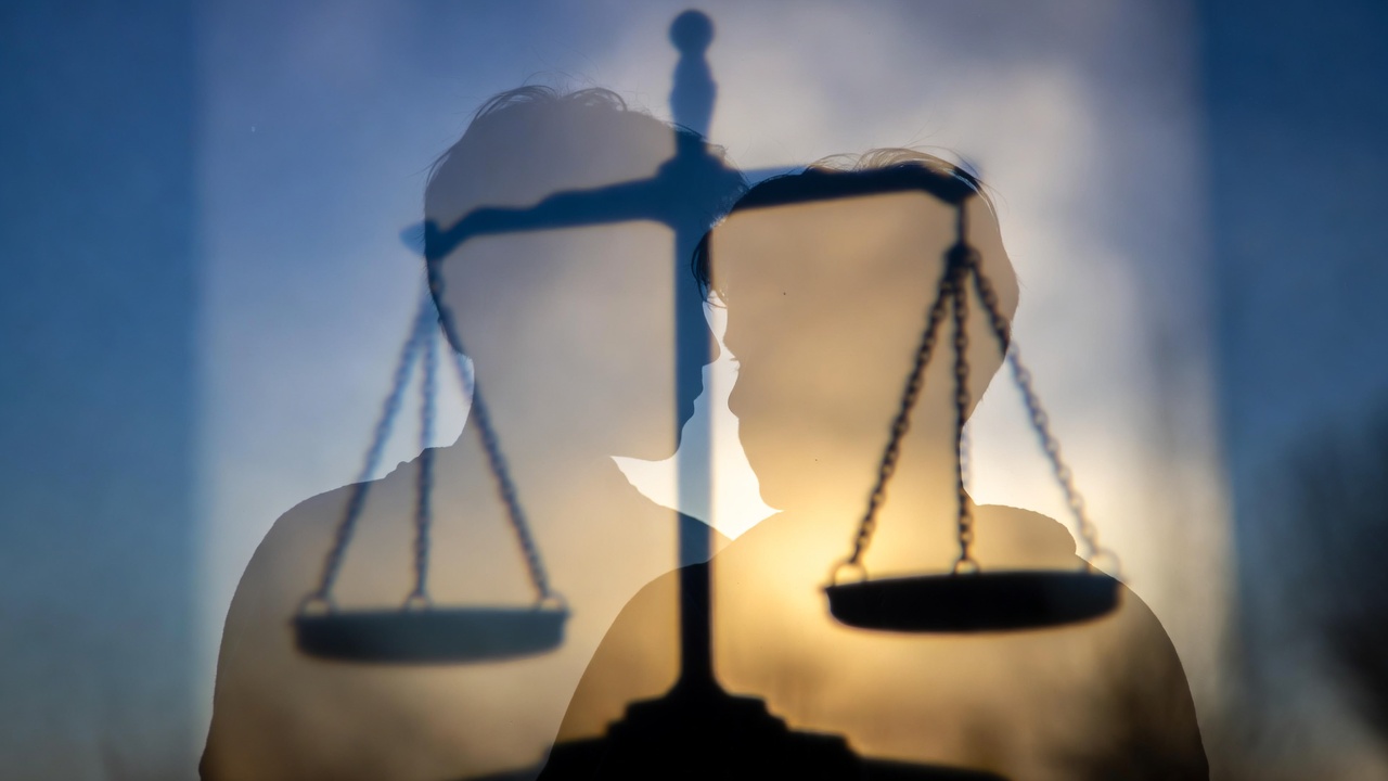 Symbolic scales of justice protecting young couple illustrating Romeo and Juliet clause relief in Michigan sex offender registry laws