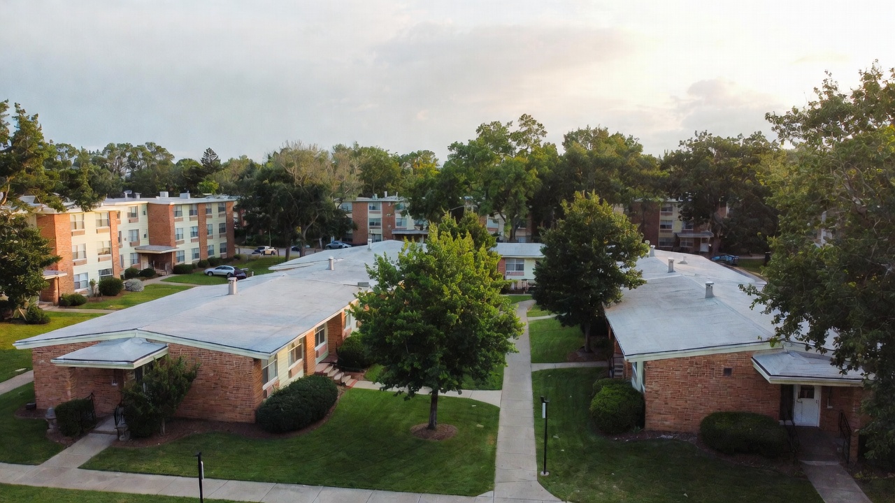 Peaceful exterior view of Hamlet West Apartments in Baltimore with tree-lined grounds and suburban charm.