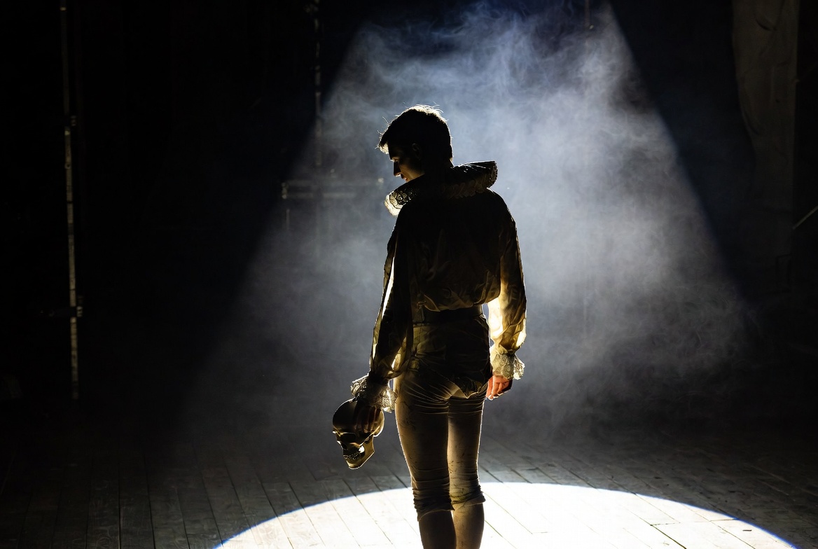 Shakespeare Macbeth poor player quote visualized with actor on empty stage and skull