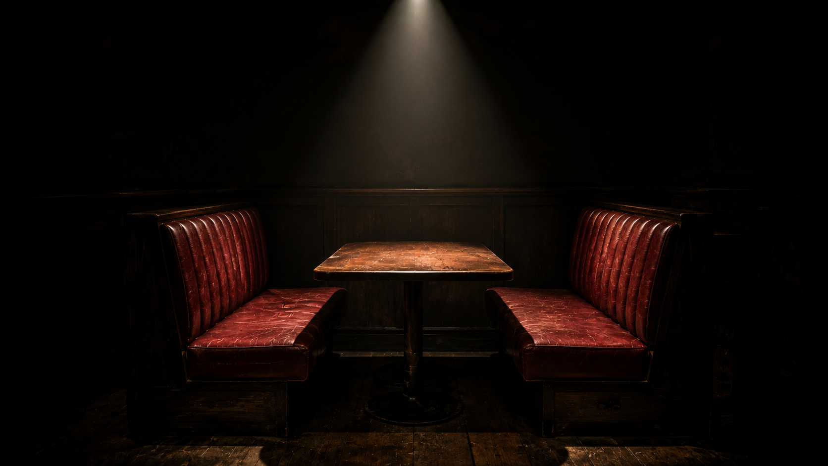 An empty spotlighted restaurant booth symbolizing the tragic closing and enduring legacy of the hamburger hamlet restaurant.